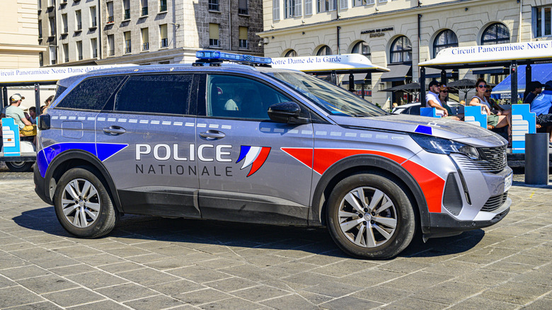 French Police car of the Police National Peugeot 5008 parked on the quay of the old port, Vieux-Port, in Marseille during a summer day.