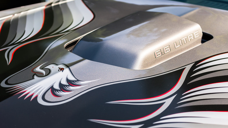 A silver 1970s Pontiac Trans-Am with hood decal