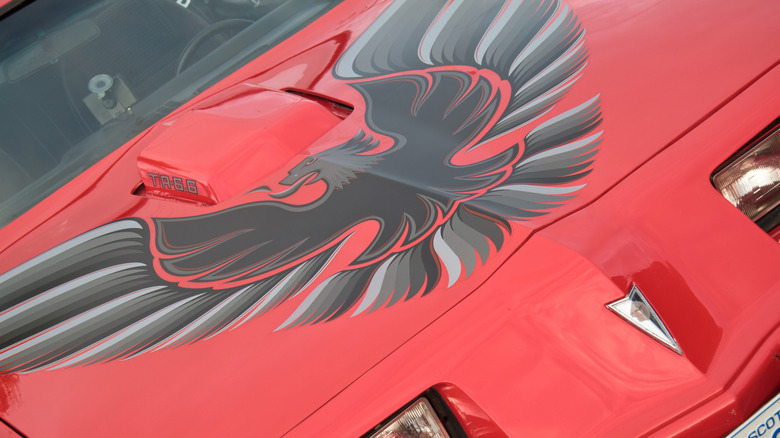 A red Pontiad Trans-Am car with hood decal