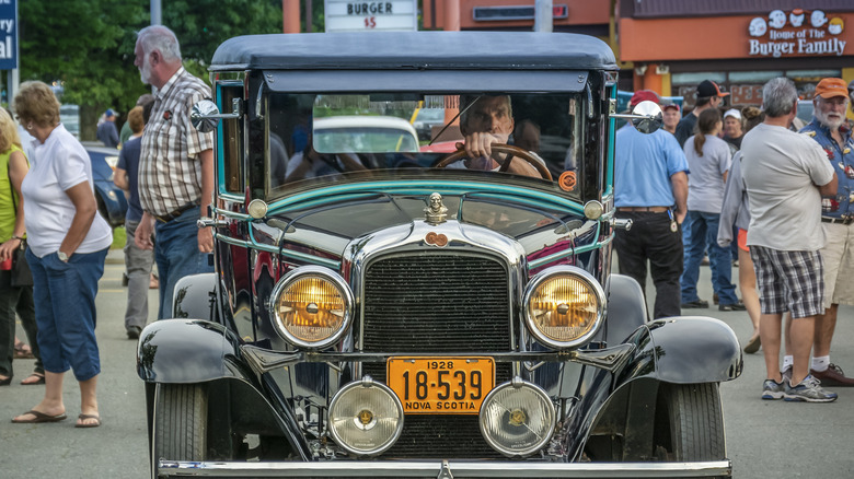 A bluish and achromatic 1928 Pontiac drives done a car show successful Nova Scotia