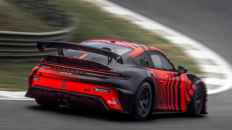 Rear 3/4 view of the Porsche 911 GT4 R on track.