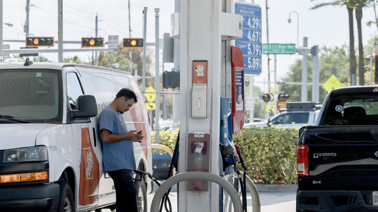 Fuel prices are displayed on a sign as a customer fills their vehicle at a gas station on April 13, 2026 in Miami, Florida.