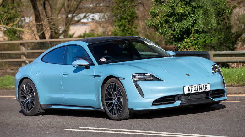 A sky blue Porsche Taycan on the road