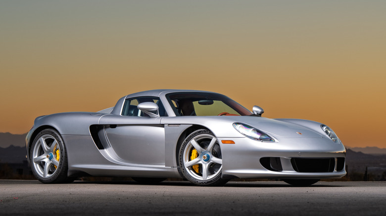 A silver Porsche Carrera GT parked on the highway