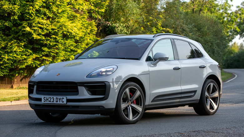 A grey Porsche Macan on a country road