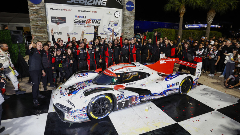 The drivers and crew of the No. 7 Porsche 963 celebrating at victory lane in Sebring