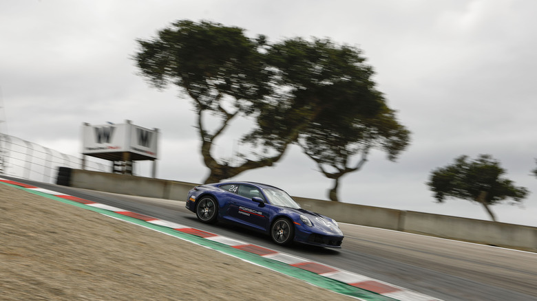 A blue Porsche 911 Carrera S driving down the Corkscrew at Laguna Seca