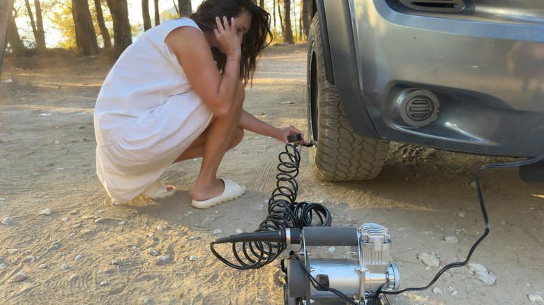 A person using a portable tire inflator