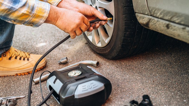 A person using a portable tire inflator