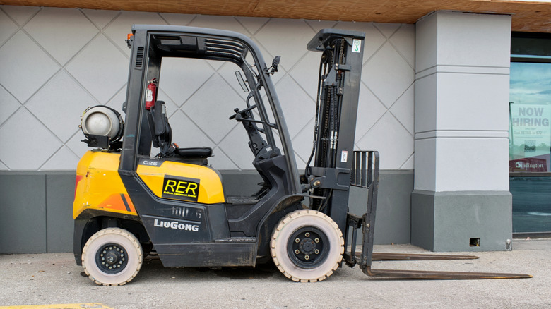 An LPG-powered forklift in Houston in front of a gray wall and storefront