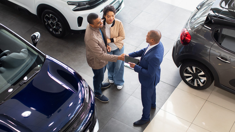 People buying a new car in a dealership.