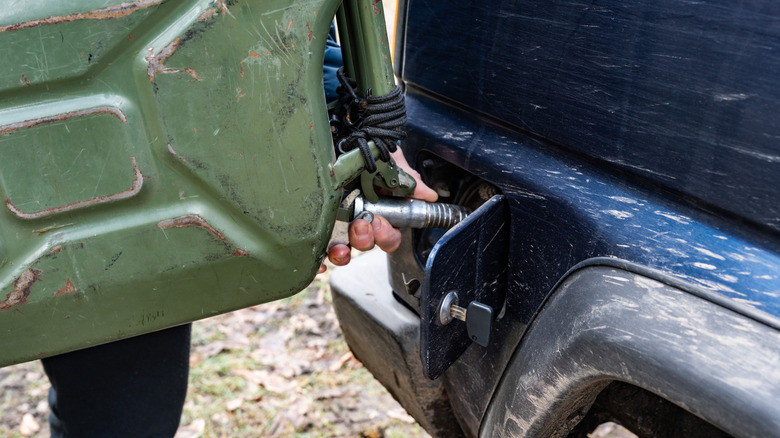 Person refueling a truck by hand.