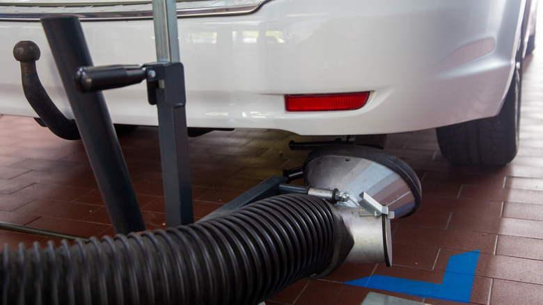 A white car taking the smog test for emissions