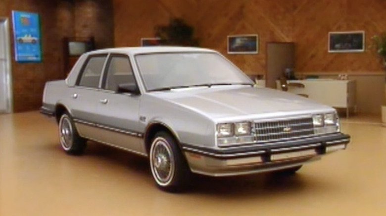 A Chevy Celebrity sits parked in a showroom.
