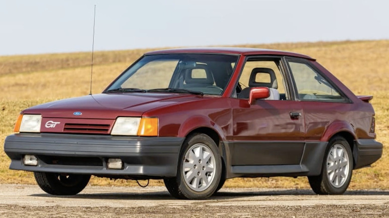 A Ford Escort sits parked among hills.