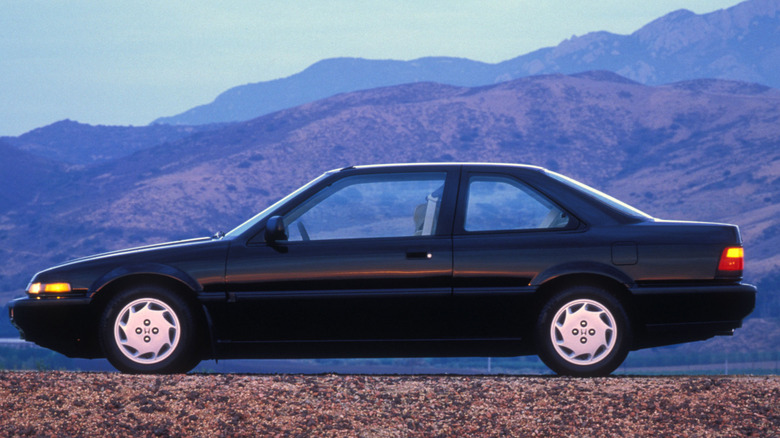 A Honda Accord sits parked against mountains.