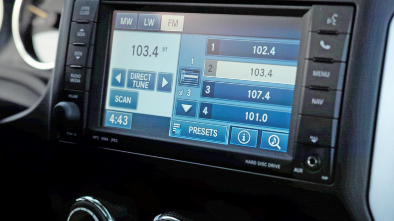 A modern infotainment system tuned to an FM radio station