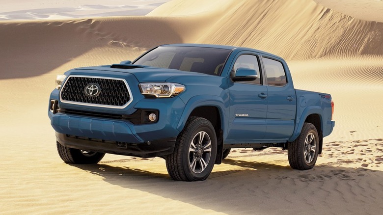 Front 3/4 view of a blue 2019 Toyota Tacoma in the desert