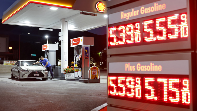 A customer washes their windshield near gas prices displayed at a gas station on July 7, 2026 in Pasadena, California.