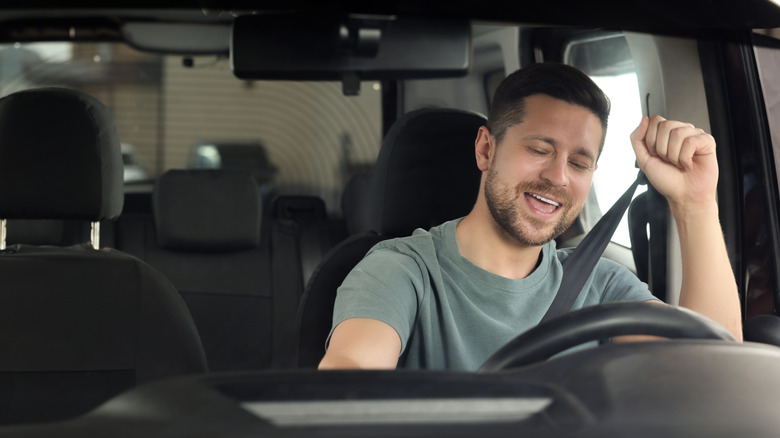 A person listening to their car's audio system
