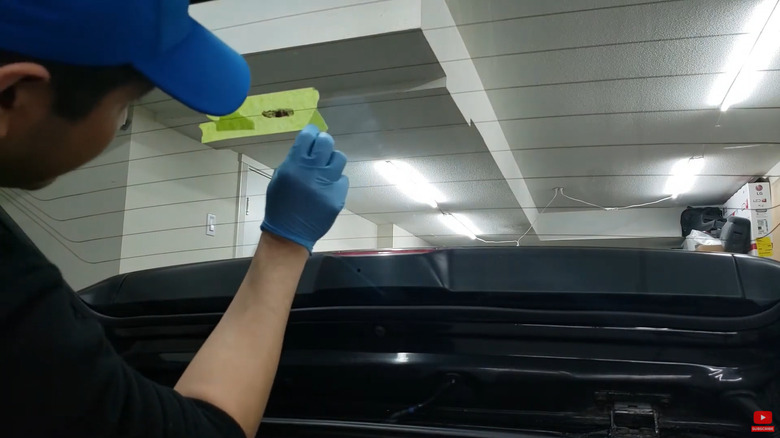 A technician repairing the rear defroster filament