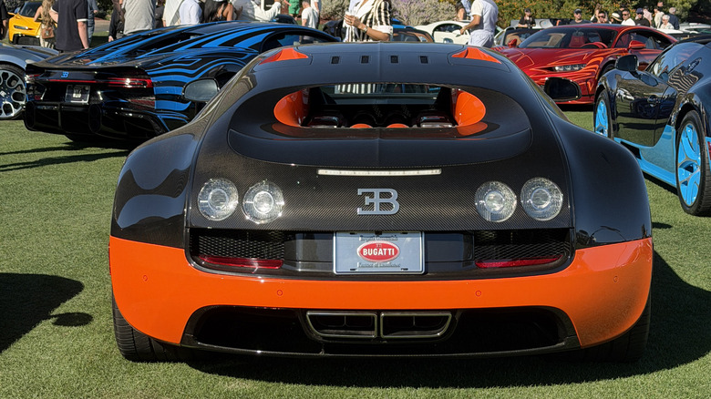 Rear extremity of a achromatic and orangish Bugatti Veyron Super Sport