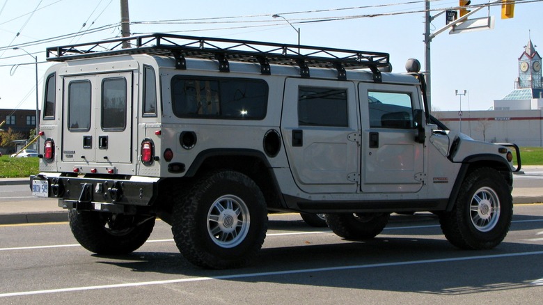 Rear 3/4 of a gray Hummer H1 at a stop light