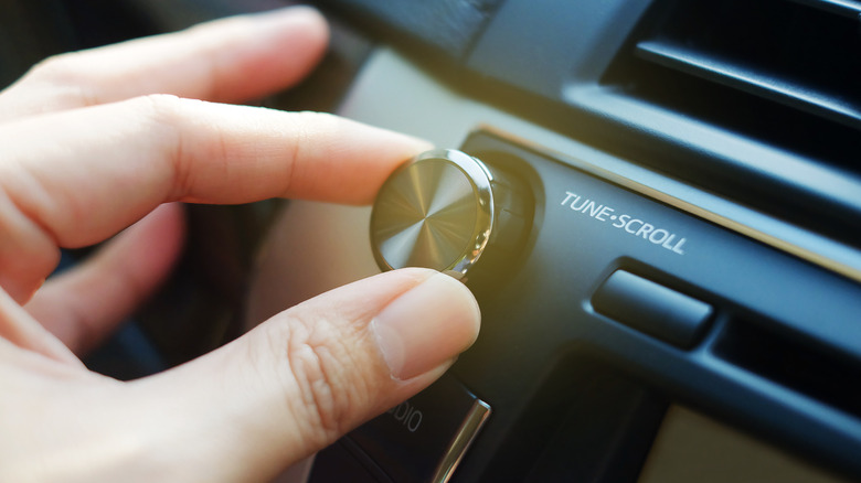 Close-up of hand tuning car audio