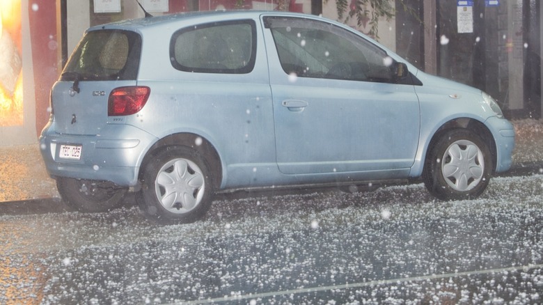 A silver hatchback car caught in hailstorm