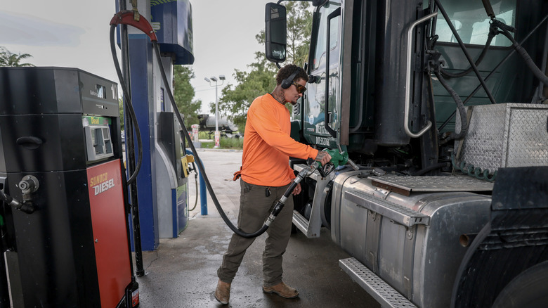 A trucker pumps diesel