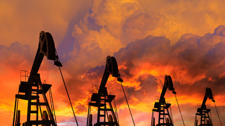Oil pumps stand in contrast to a fiery, smokey sky