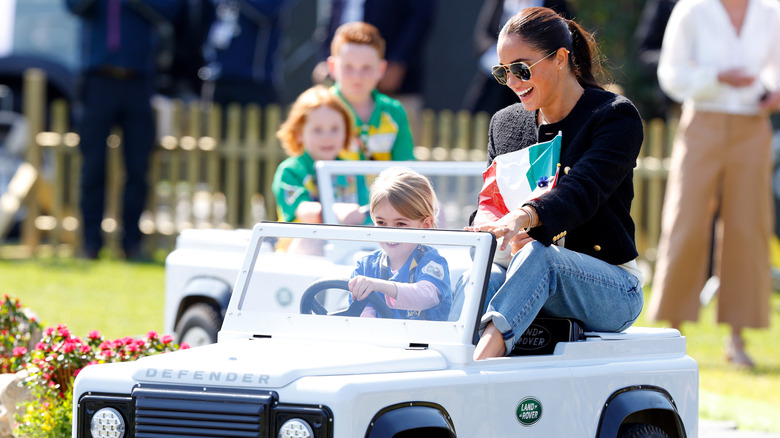 Meghan, Duchess of Sussex accompanies a young girl as she drives a mini Land Rover Defender at the Land Rover Driving Challenge, on day 1 of the Invictus Games 2020 at Zuiderpark on April 16, 2022 in The Hague, Netherlands.
