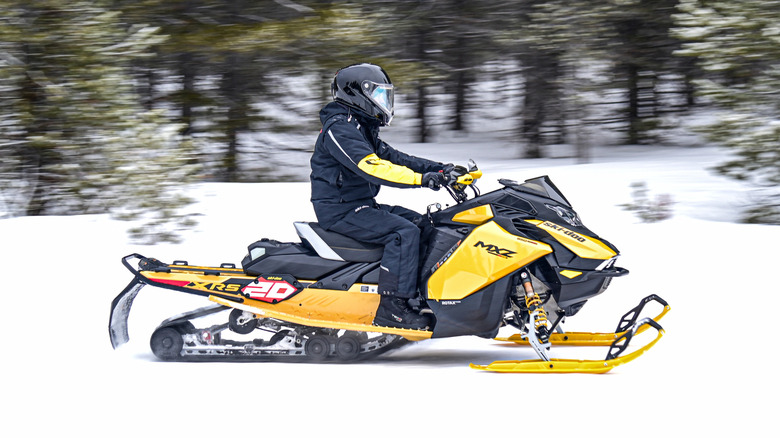 Side profile view of a Ski-Doo MXZ snowmobile in yellow