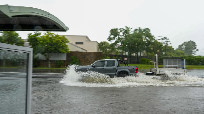 a truck drives through a flood street