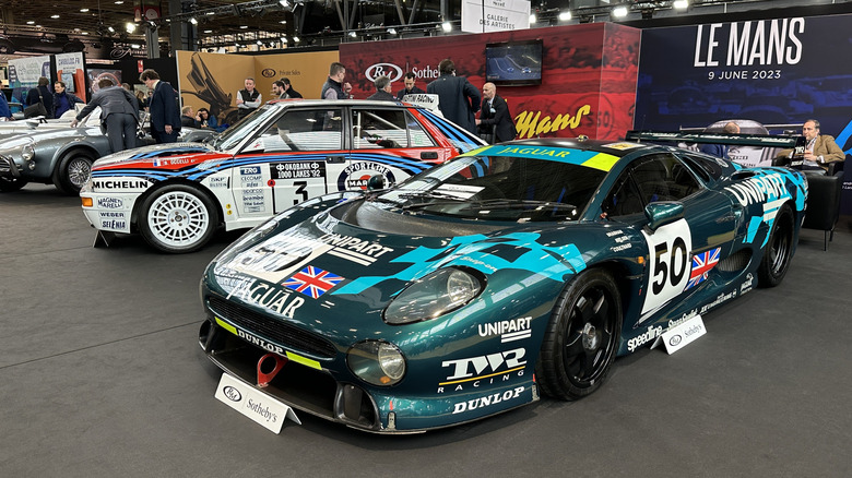 A Jaguar XJ220 race car next to a Lancia Delta Integrale rally car at Rétromobile Paris 2023