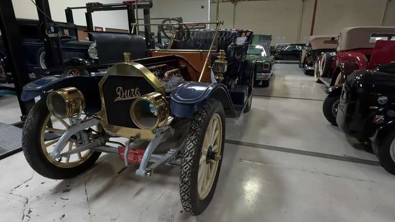 An exhibit in Murphy Auto Museum with a 1910 Durocar prominently featured with cars of other eras beside and behind it