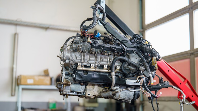 Engine suspended above the ground by an engine hoist