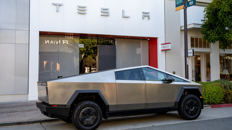 a cybertruck parked in front of a tesla store