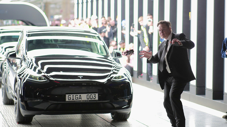 Elon Musk doing the electric slide in front of a Model S