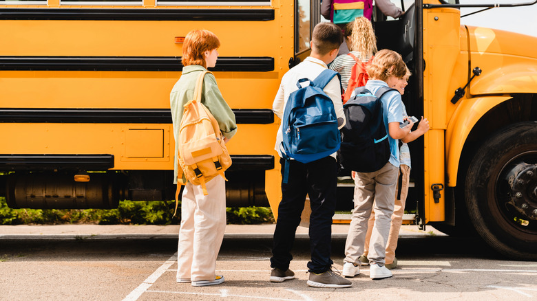 A group of kids getting on a school bus