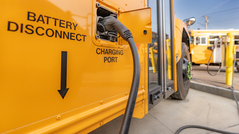 An electric school bus plugged into a charger