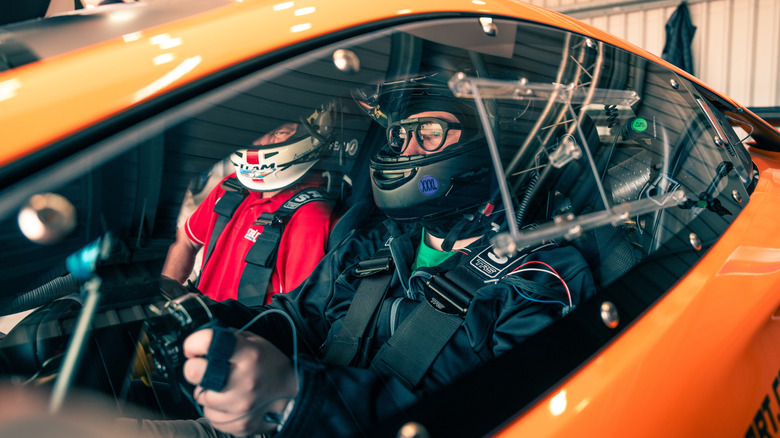 A driver wired with sensors belted into a McLaren before hitting the track