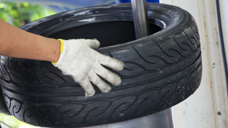 A technician mounting a new tire into the wheel