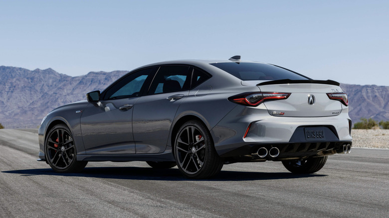 an acura tlx on a desert road on a clear day with mountains in the back ground.