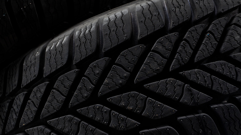 A car tire's treads against a black background
