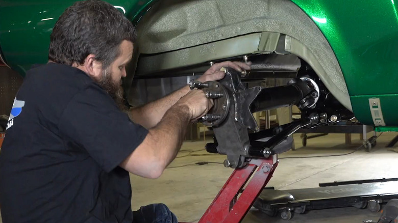 Man installing rear suspension for 1968 Ford Mustang EXP 500 restoration