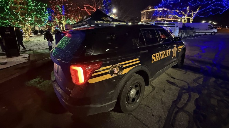 Rear 3/4 view of a Lorain County Sheriff cruiser parked in front Christmas lights