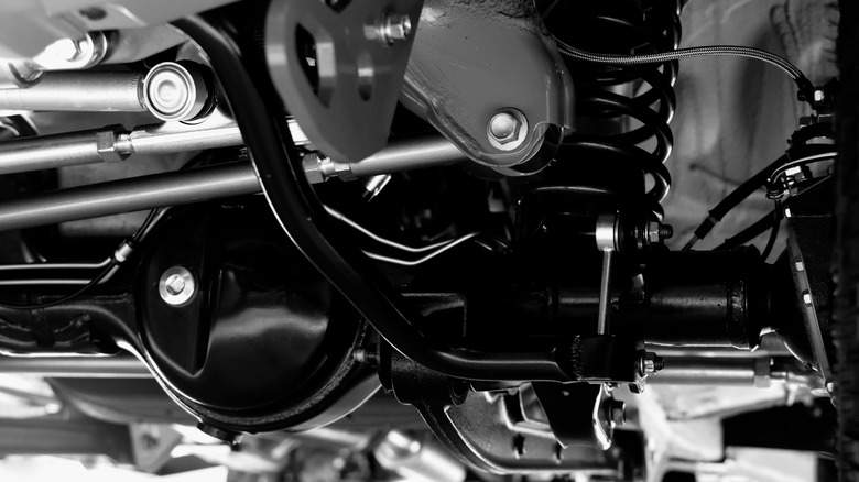 A closeup of a car's suspension system in black and white