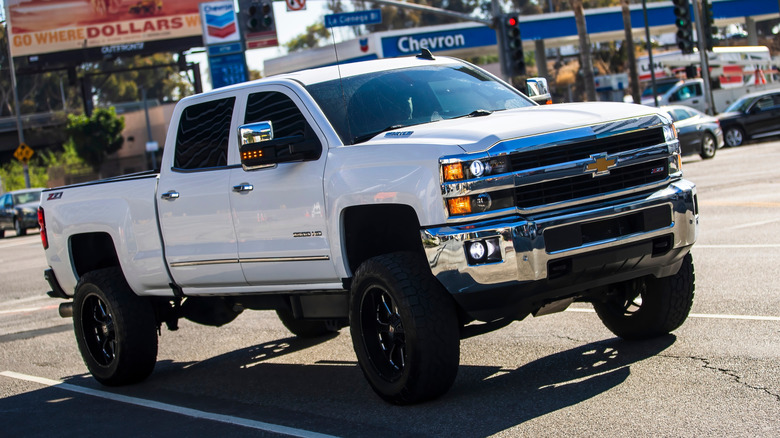 A white lifted Chevrolet Silverado pickup truck