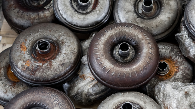 A pile of old and used torque converters on the shop floor
